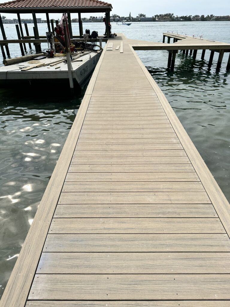 Composite dock walkway leading out to a covered boat slip on open water. Dock construction by Anderson Dock and Lift, Sarasota FL.