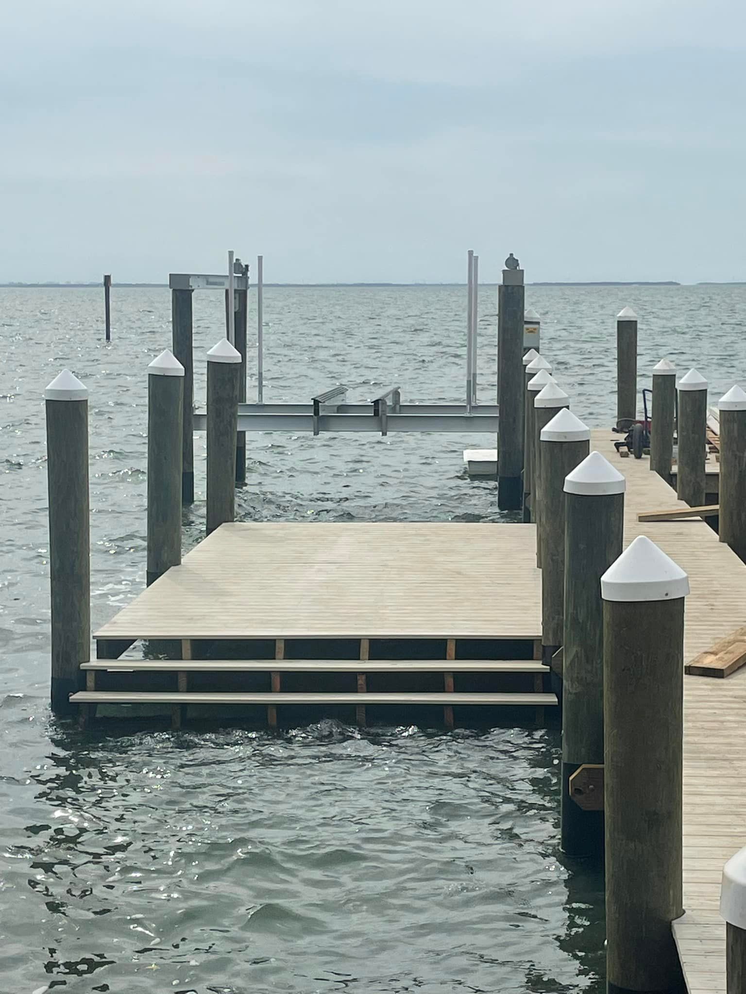 Capped pilings, deck platform and boat lift beams on an open bay dock. Dock and pier inspections, Anderson Dock and Lift, Manatee County FL.