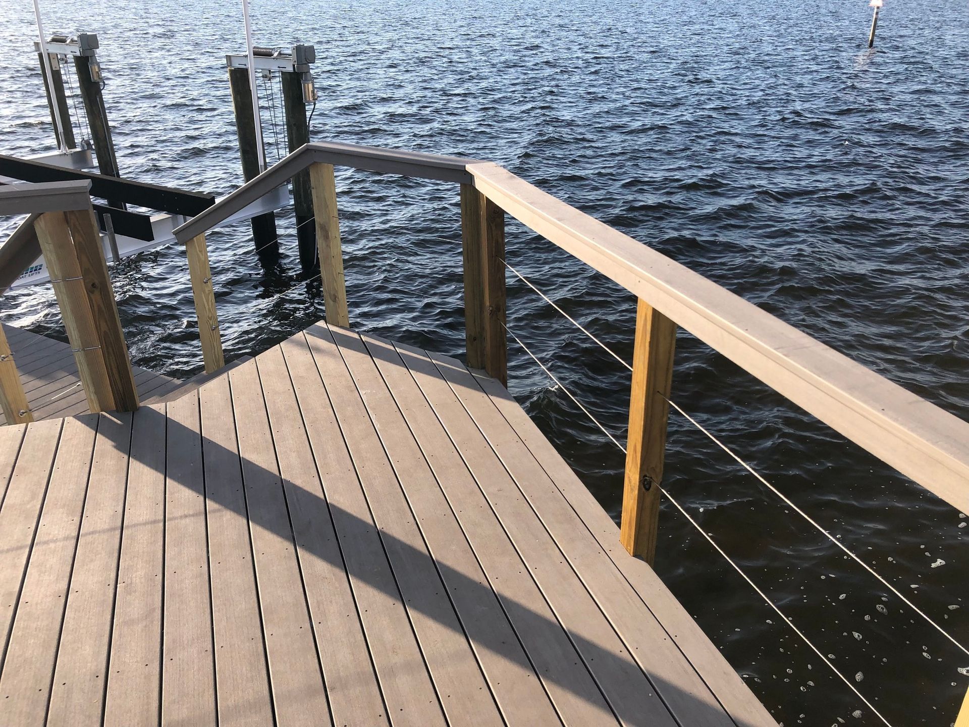 New composite dock with cable railing beside a boat lift. New dock construction, Anderson Dock and Lift, Bradenton FL.