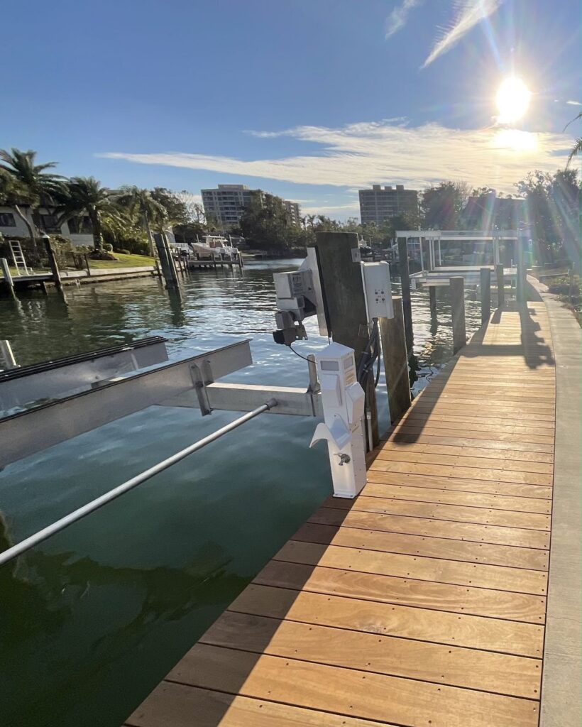 Ipe Brazilian hardwood dock decking in afternoon sun beside a boat lift on a residential canal. High end hardwood dock construction, Anderson Dock and Lift, Sarasota FL.