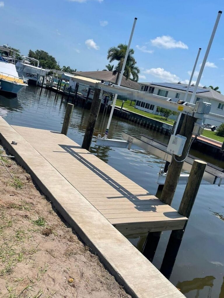 New concrete seawall cap, composite dock and boat lift on a residential canal. Seawall, dock and boat lift construction, Anderson Dock and Lift, Bradenton FL.