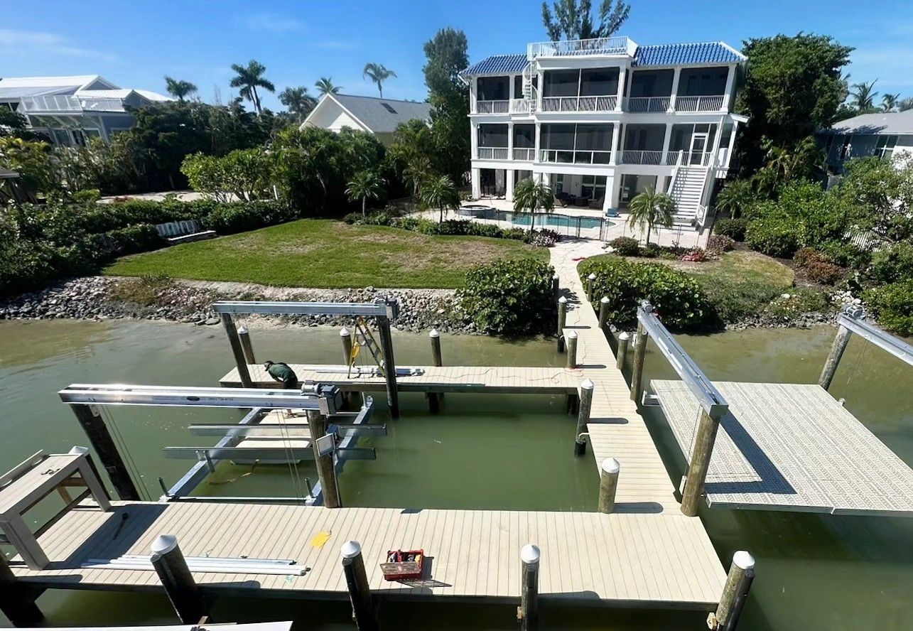 Waterfront home with a composite dock and two aluminum boat lifts on a canal. Boat lift installation by Anderson Dock and Lift, St. Petersburg FL.
