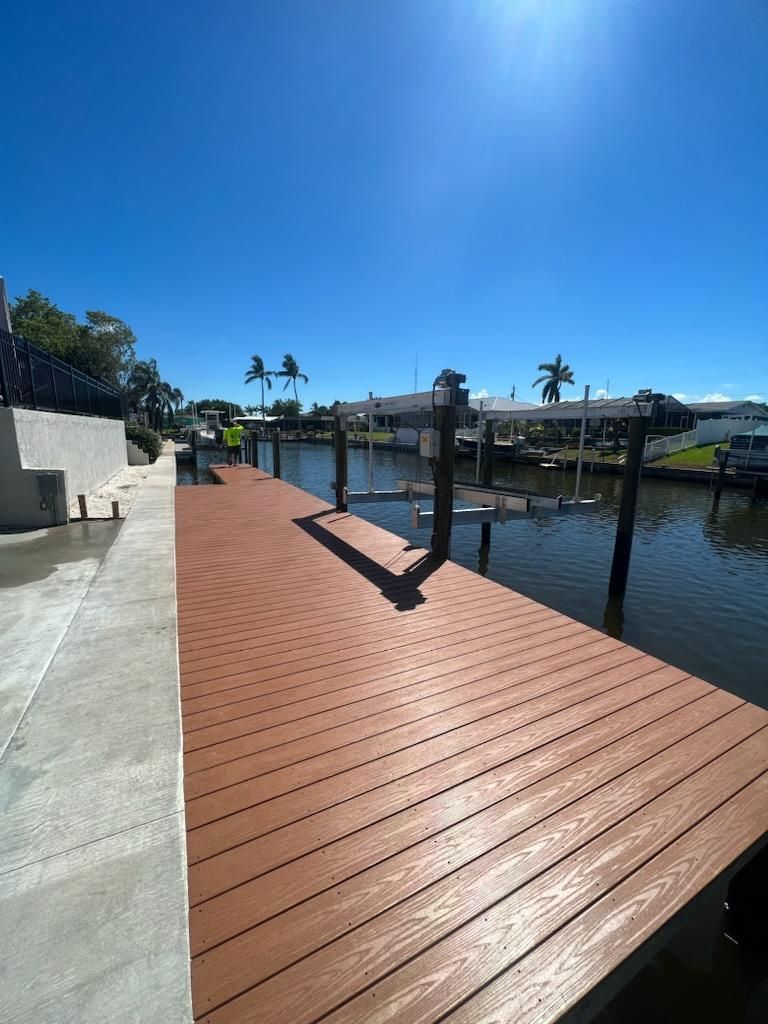 Brown composite dock on a canal under a clear sky. Composite dock construction by Anderson Dock and Lift, Bradenton FL.