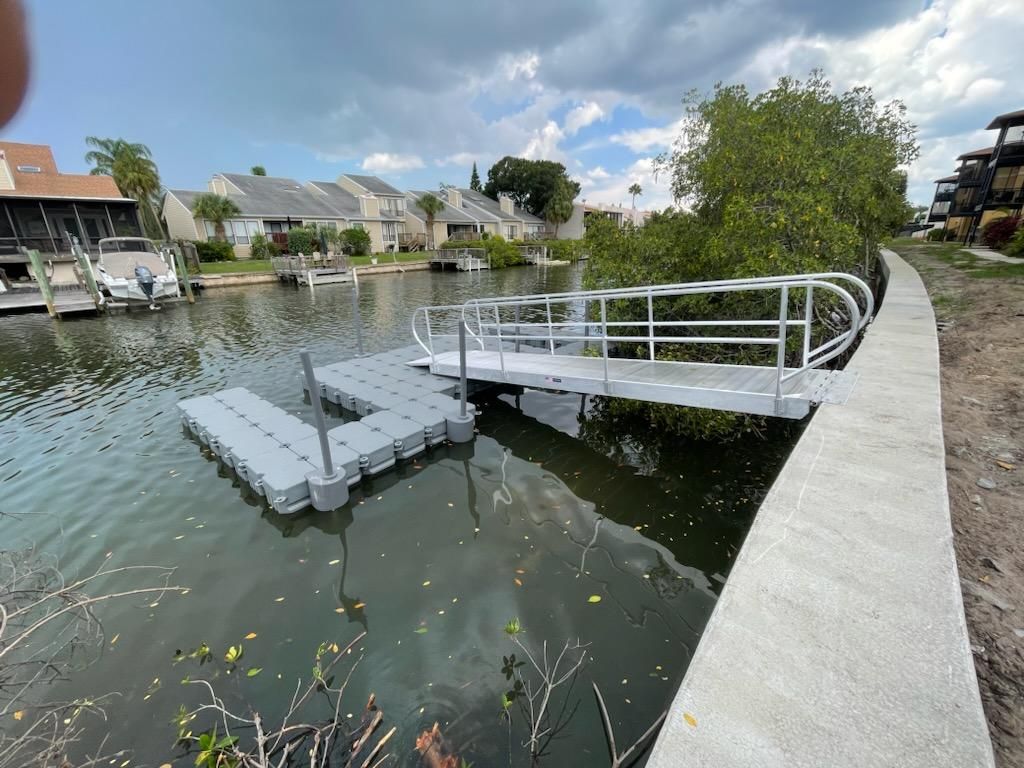 Floating dock and aluminum gangway at an association seawall. Floating dock builder Anderson Dock and Lift, Bradenton FL.