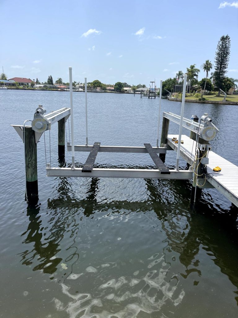 Boat lift set on a wooden dock over an open waterway. Boat lift installation by Anderson Dock and Lift, Sarasota County FL.