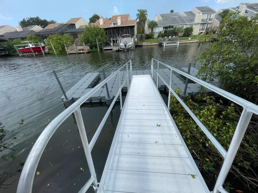 Aluminum gangway leading to a floating dock. Floating dock and gangway installation by Anderson Dock and Lift, Sarasota FL.