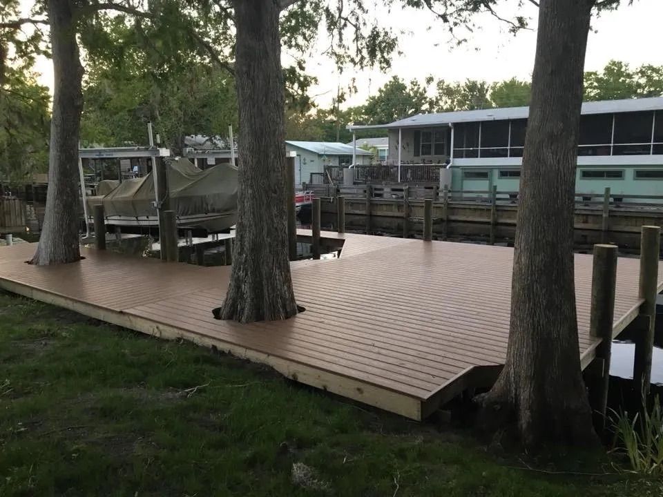 Dock built around three trees extending into the water. Custom dock construction by Anderson Dock and Lift, Sarasota FL.
