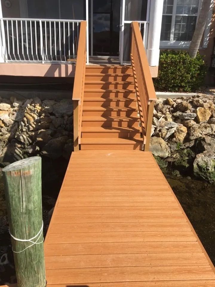Composite walkway and stairs running up from the water over a rock shoreline. Custom dock construction by Anderson Dock and Lift, Apollo Beach FL.