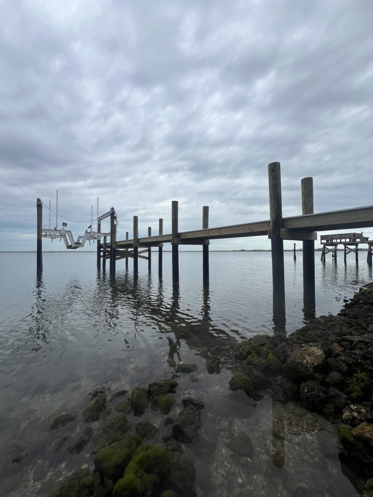 Dock crossing a heavy rock revetment out to a boat lift. Dock and seawall construction by Anderson Dock and Lift, Cortez FL.