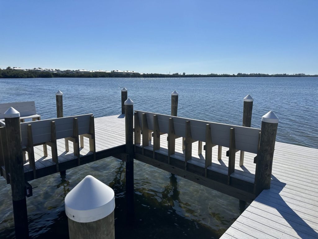 Composite dock T head with built in bench seating and capped pilings. Custom dock construction by Anderson Dock and Lift, Apollo Beach FL.
