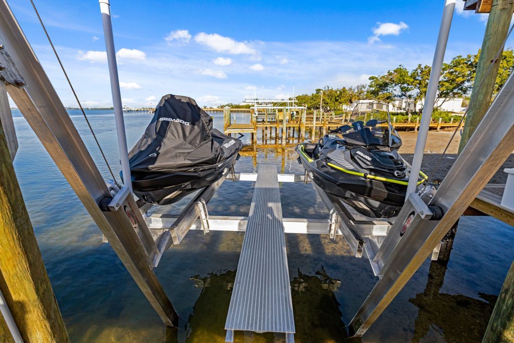 Two personal watercraft on a dual cradle lift over shallow water. PWC lift installation, Anderson Dock and Lift, Sarasota FL.